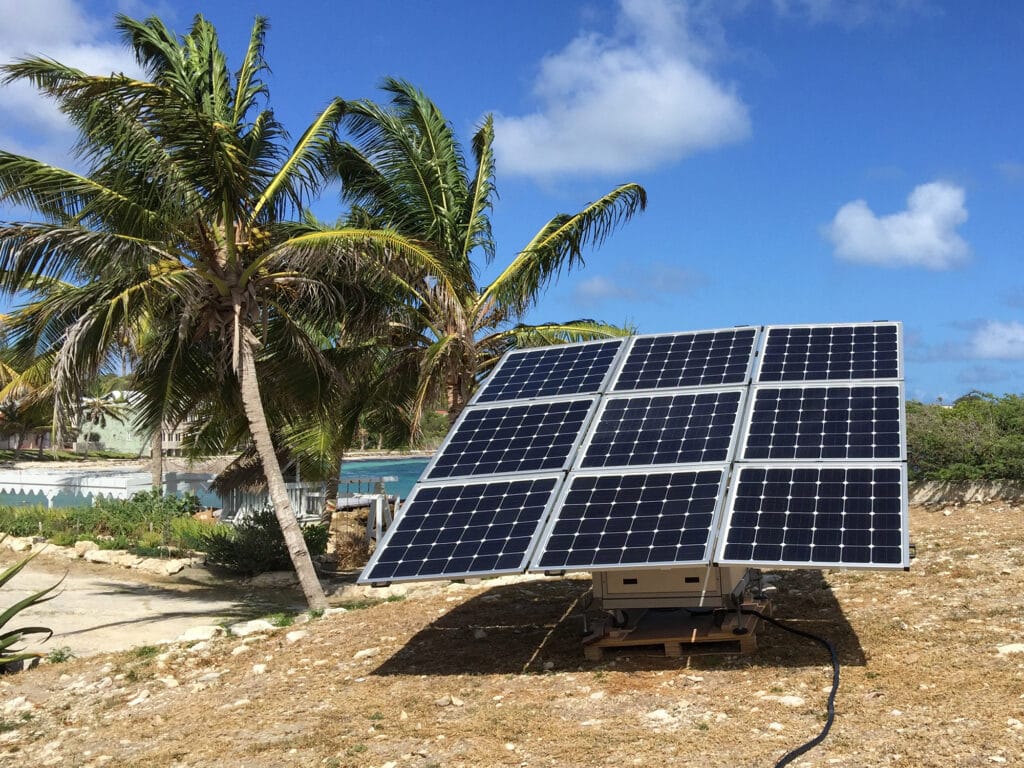 Die netzunabhängige Solarlösung sun2go xl, installiert in Antigua und Barbuda neben Palmen.